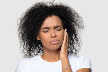 woman in pain holding jaw | tooth extraction scarborough on