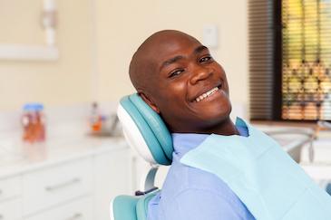 man sitting in dentist exam chair smiling | dentist scarborough