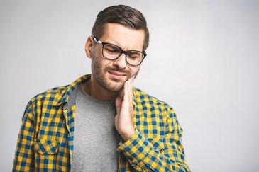 man in plaid shirt in pain | root canal treatment scarborough