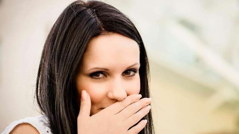 woman putting hand over mouth | dental clinic scarborough