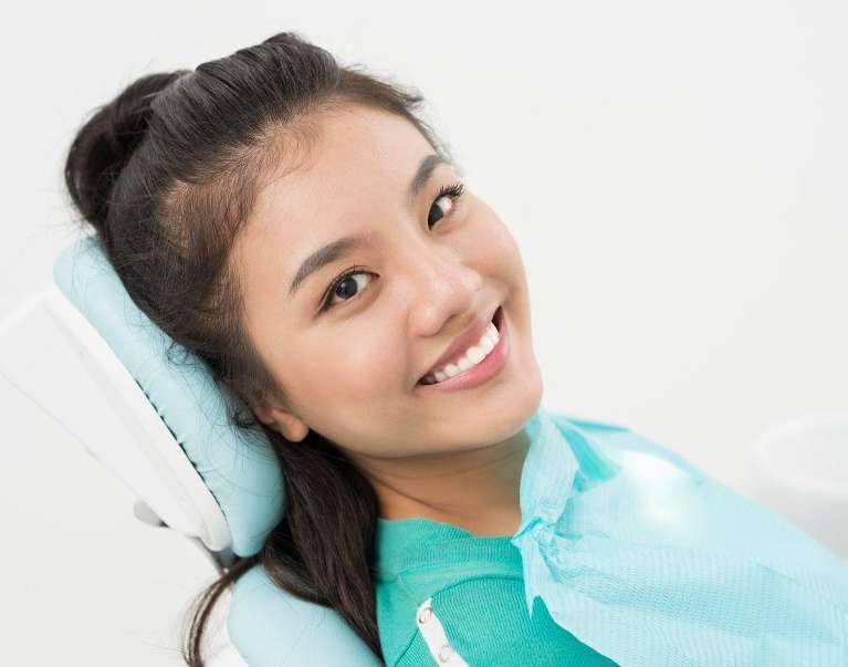 An asian woman smiling after getting Dental Crowns in Scarborough, ON