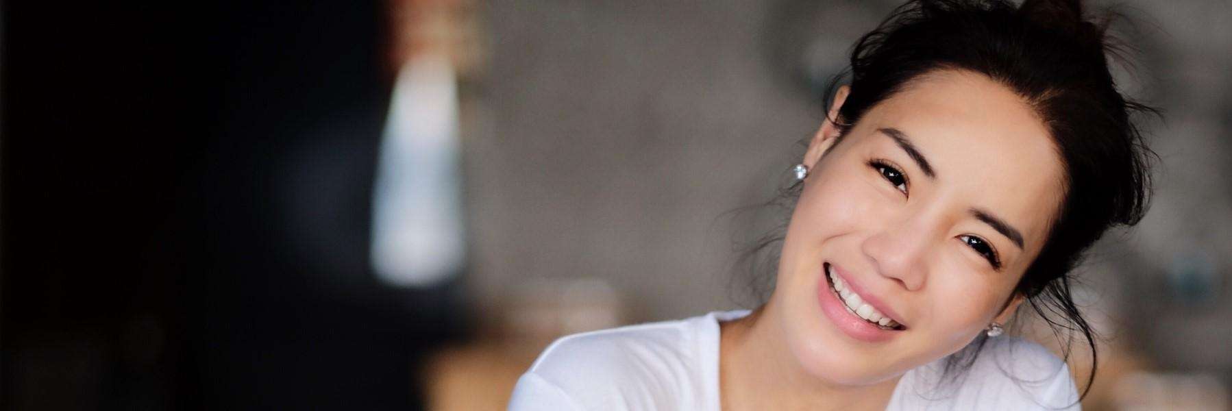 woman with black hair smiling | TMJ Pain Relief